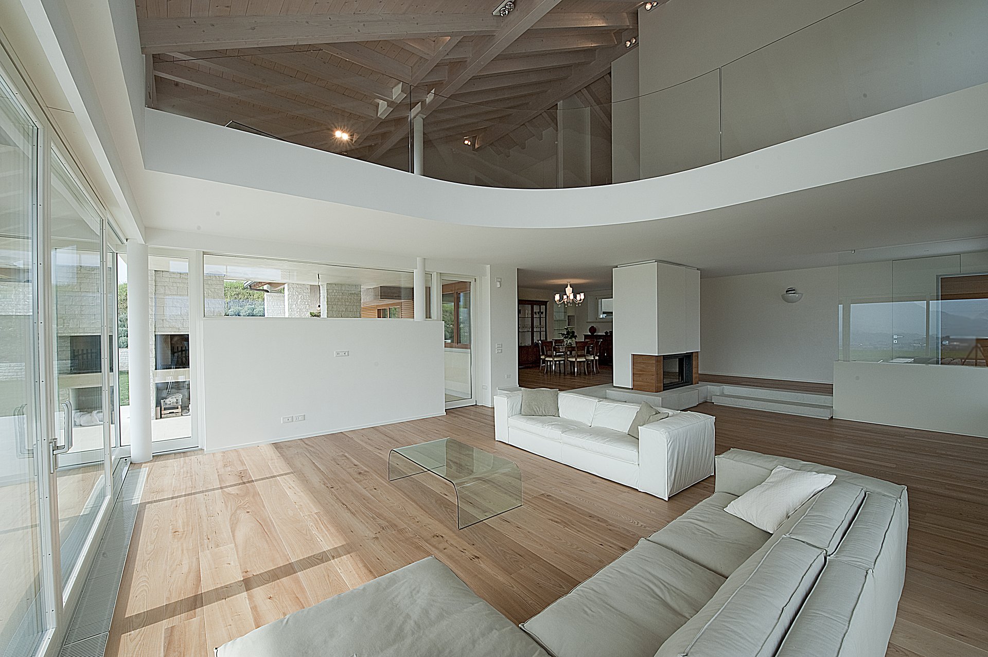 Pavimento in frassino, living con soffitto a travi