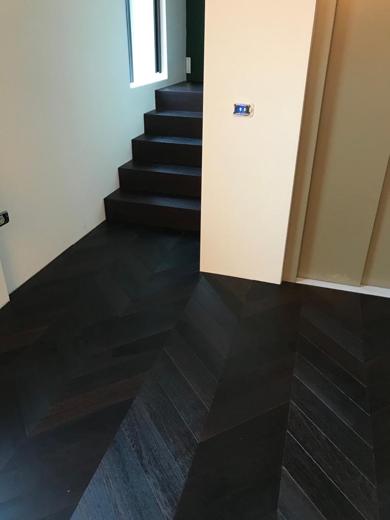 Scala in rovere tinto scuro in continuità con il pavimento